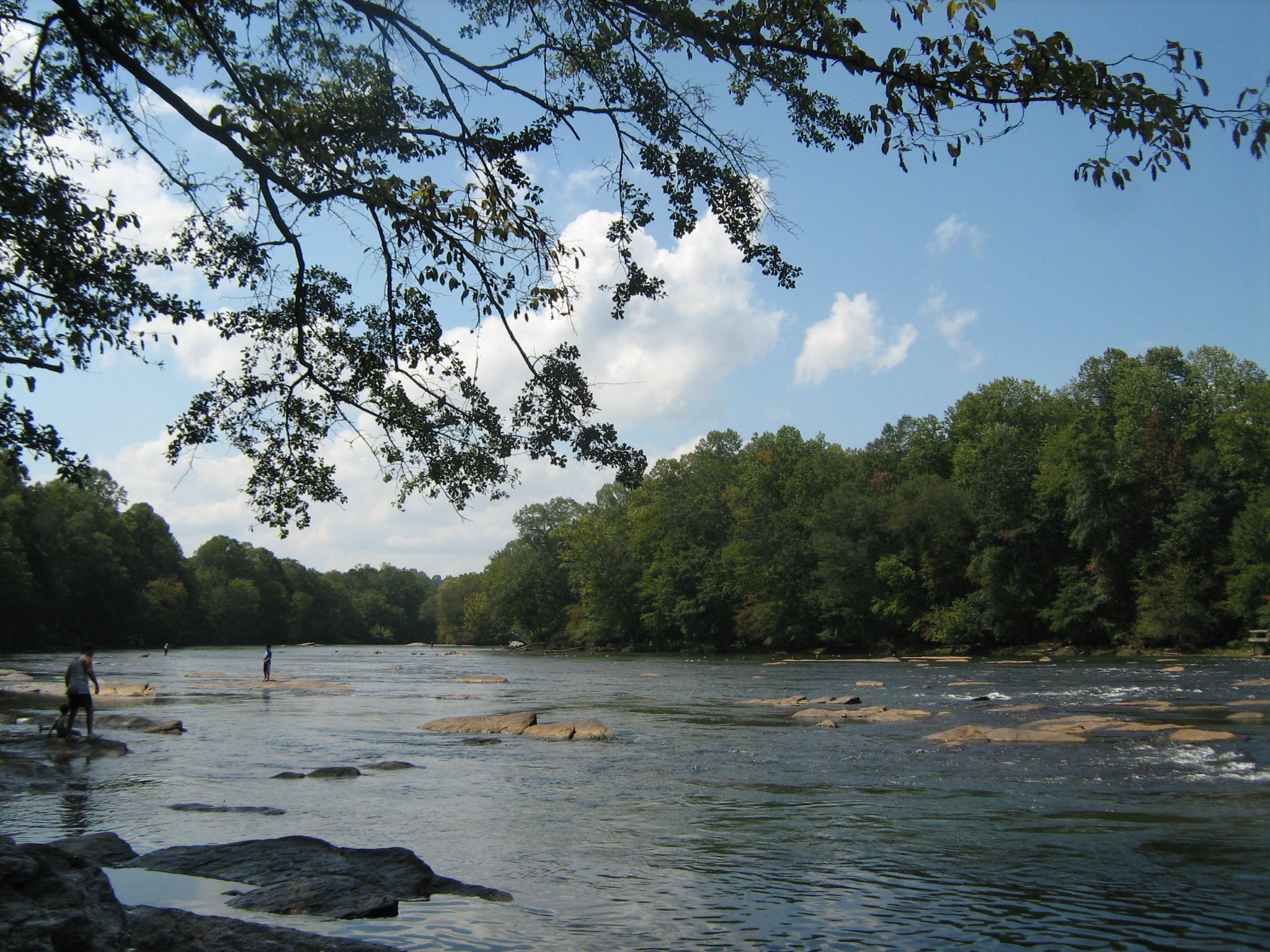 Chattahoochee River at Norcross, Georgia, with shallow water, exposed rocks and wooded banks